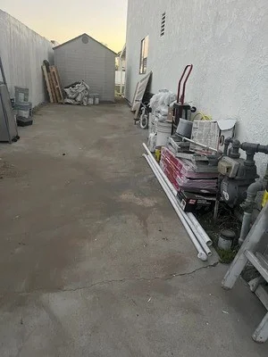 Cleared residential yard with removed junk and debris piled for hauling