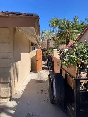 Side yard junk removal showing cleared debris and restored patio space with palm trees