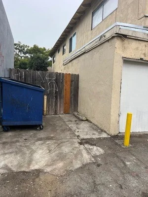 Commercial alley with cleared concrete surface, removed wood debris and scrap materials