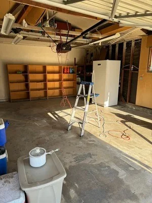 Empty garage with concrete floor after junk removal, shelving units and appliances hauled away