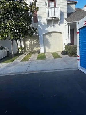 Clean concrete driveway with cleared landscape beds and manicured lawn