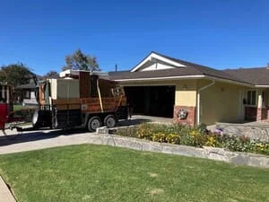 Loaded junk removal truck with furniture and household items removed from residential home
