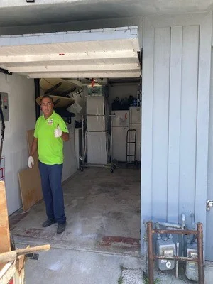 Empty garage interior after junk removal, concrete floor cleared of debris and boxes